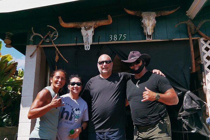 Charlie with guests at the home base, mounted skulls behind.